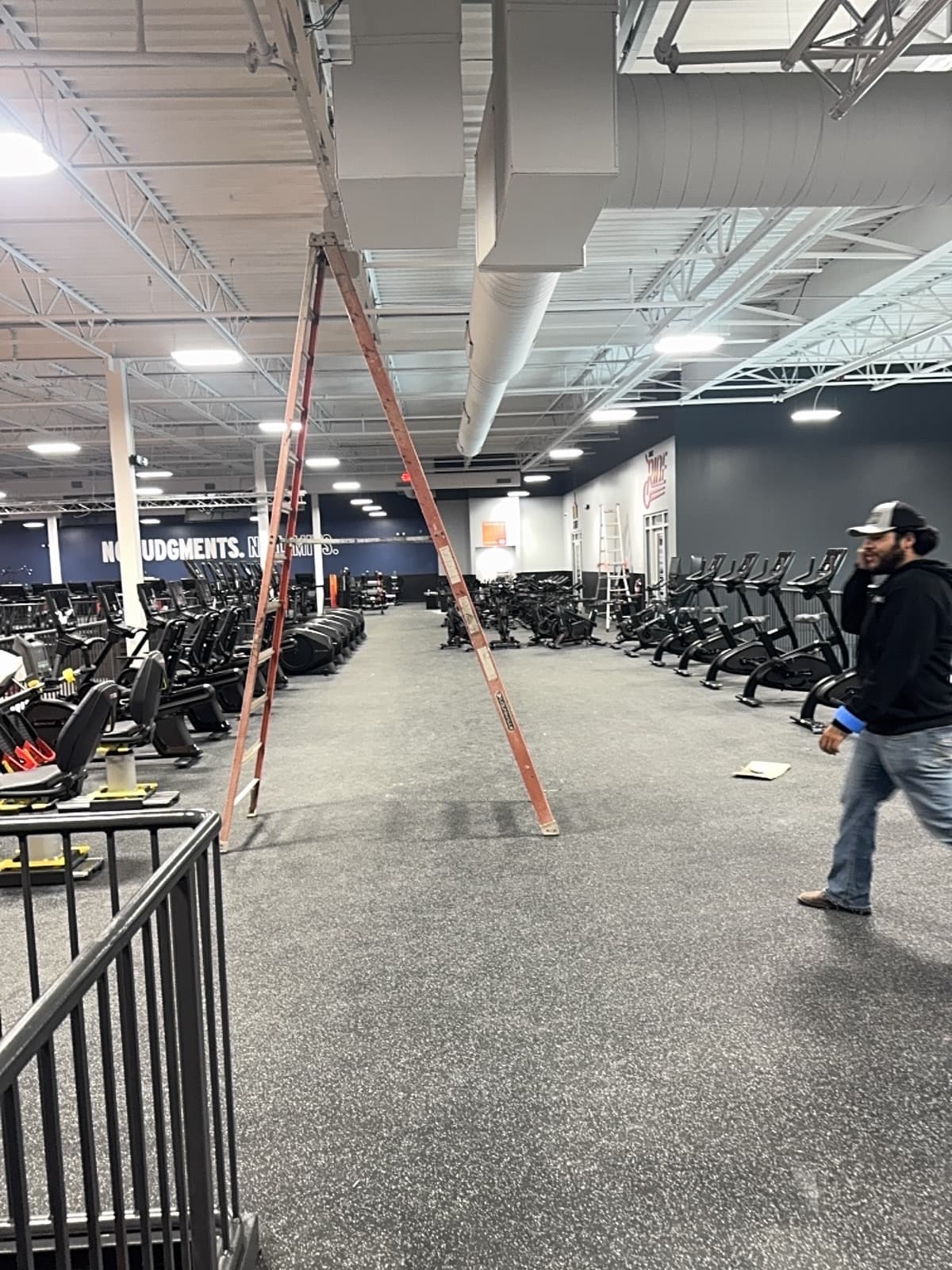 Crunch Fitness main gym with ladders and trade activity before final cleaning